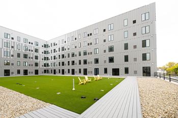 the courtyard of a building with lawn and chairs